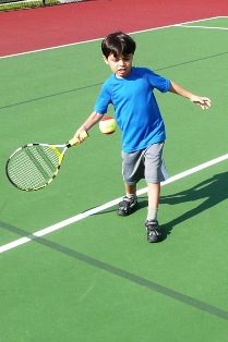 little boy playing tennis